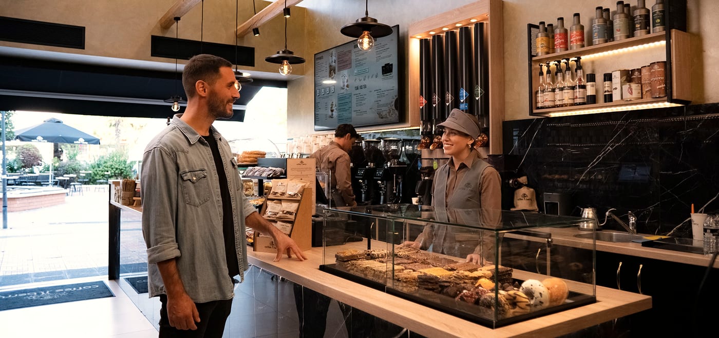 A customer and a Coffee Berry barista at the counter